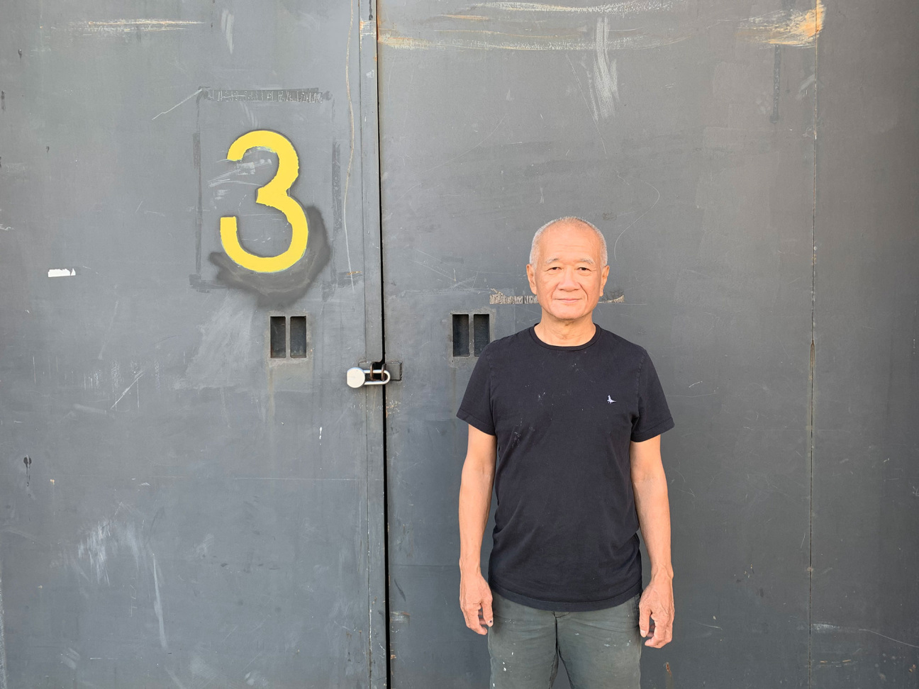 man standing against wall with three on it