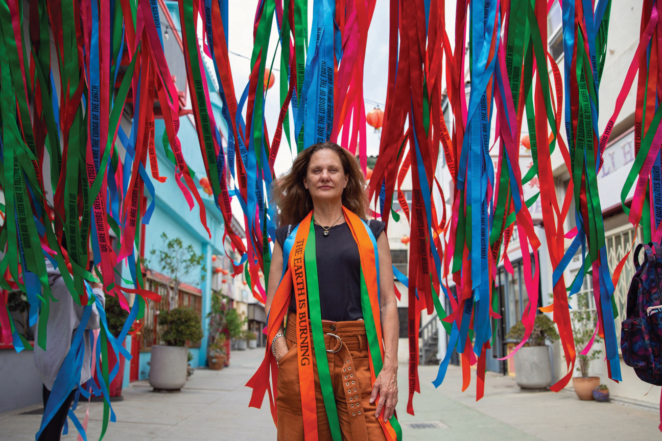 A woman standing in front of hanging ribbons.