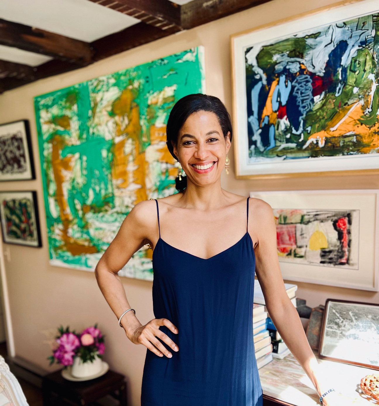 Art curator Eden Williams standing in front of paintings.