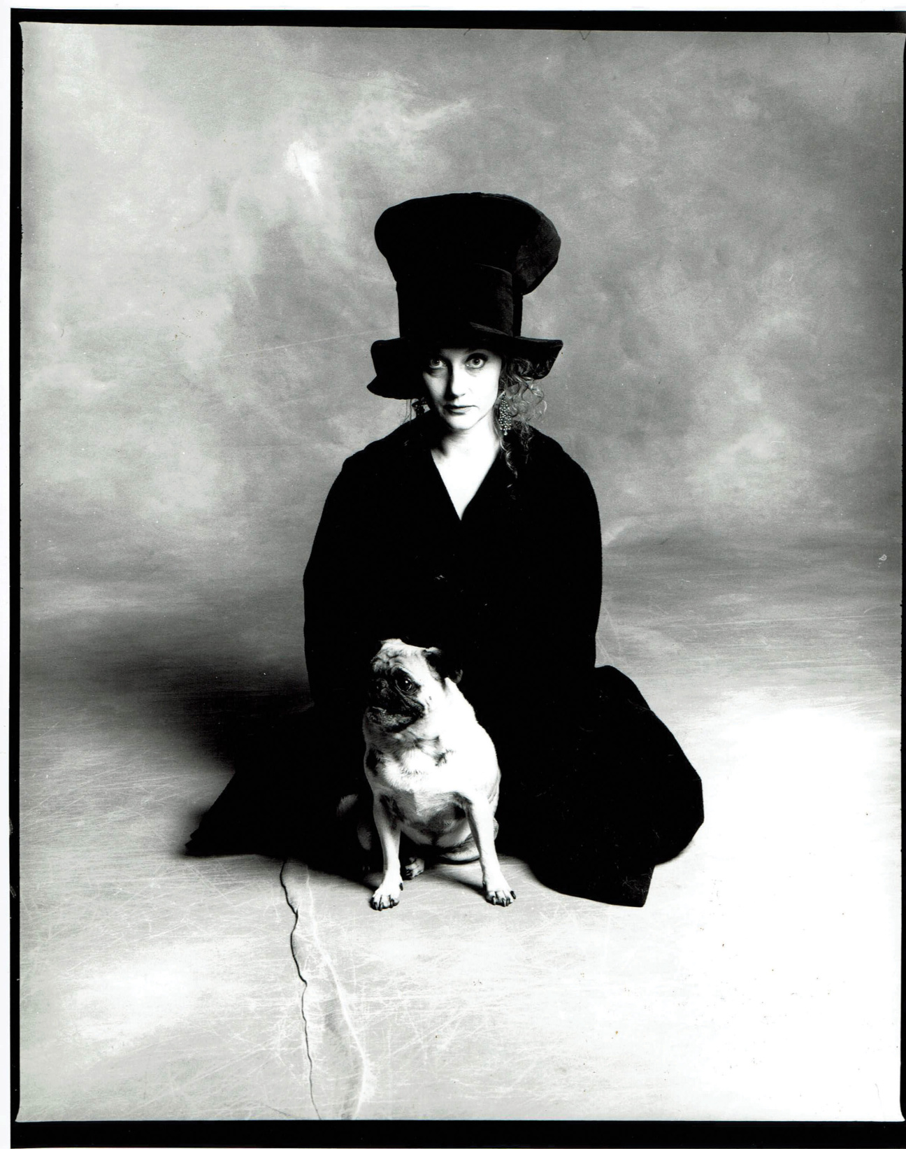 A woman sitting with a dog.